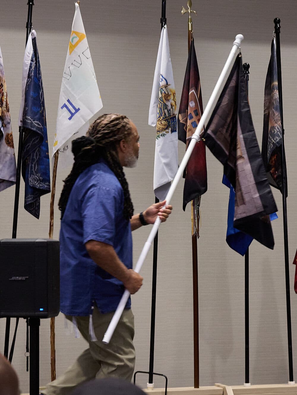 A man carrying his family's standard past the others